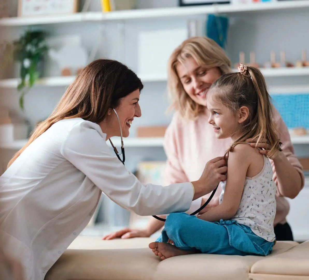 Doctor examining smiling child with stethoscope