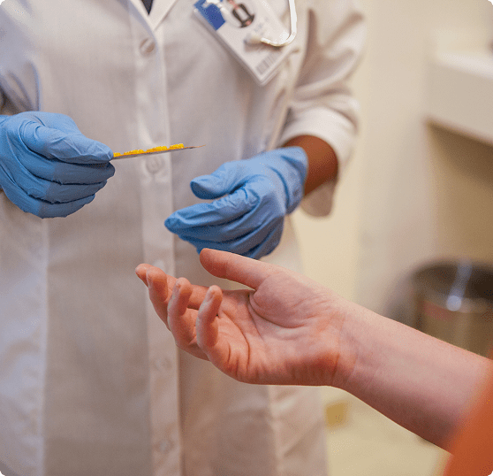 Doctor preparing injection for patient's hand.
